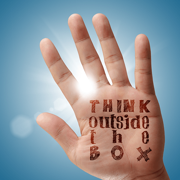 Think Outside the Box written on a hand.